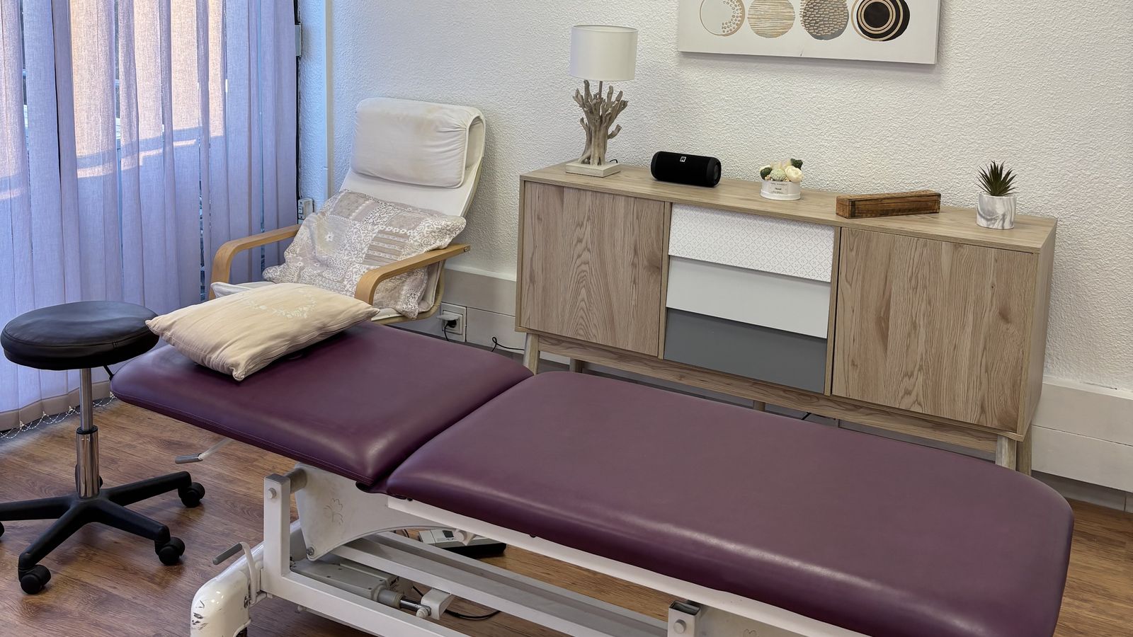 La table de soin électrique du cabinet d'ostéopathie à Allauch, avec son coussin et le fauteuil de détente